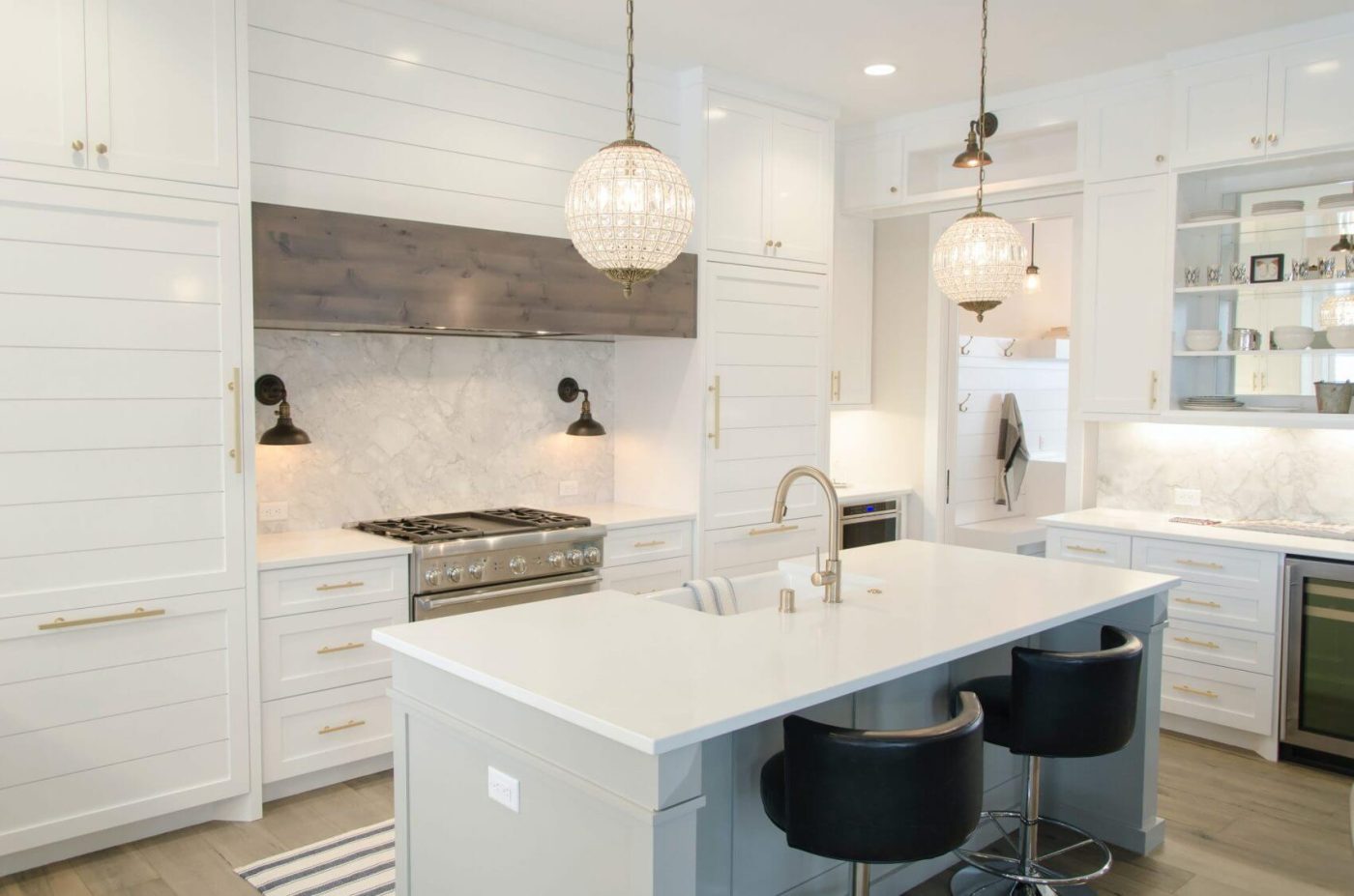 Cocina moderna de lujo con isla central, gabinetes blancos, encimeras de cuarzo y lámparas colgantes de cristal - Serdava